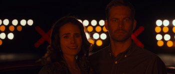 Movie still from “Fast & Furious 6” (2013), directed by Justin Lin – A man and a woman standing next to each other in front of lights; Close Up shot, Over the shoulder angle