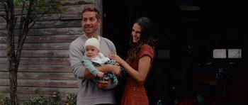 Movie still from “Fast & Furious 6” (2013), directed by Justin Lin – A man and a woman holding a baby and smiling for the camera; Medium shot, Over the shoulder angle