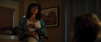 Movie still from “Fast X” (2023), directed by Justin Lin – A woman holding a handgun while standing in a room; Medium shot, Over the shoulder angle