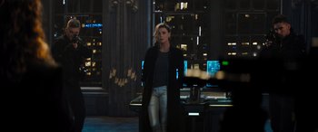 Movie still from “Fast X” (2023), directed by Justin Lin – A woman standing in front of a computer desk; Medium shot, Over the shoulder angle