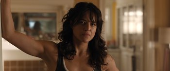 Movie still from “Fast X” (2023), directed by Justin Lin – A person with long black hair; Close Up shot, Over the shoulder angle