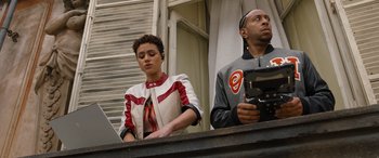 Movie still from “Fast X” (2023), directed by Justin Lin – A man and a woman standing next to each other on a balcony; Medium shot, Low angle