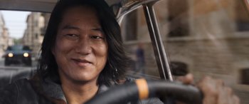 Movie still from “Fast X” (2023), directed by Justin Lin – A man sitting in the driver's seat of a car; Close Up shot, Over the shoulder angle