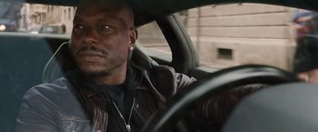 Movie still from “Fast X” (2023), directed by Justin Lin – A person sitting in a car; Close Up shot, Over the shoulder angle