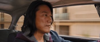 Movie still from “Fast X” (2023), directed by Justin Lin – A man sitting in the passenger seat of a car looking out the window; Close Up shot, Over the shoulder angle