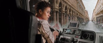 Movie still from “Fast X” (2023), directed by Justin Lin – A woman sitting in the driver's seat of a bus; Medium shot, Over the shoulder angle