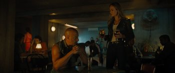 Movie still from “Fast X” (2023), directed by Justin Lin – A man and a woman sitting at a table; Medium shot, Over the shoulder angle