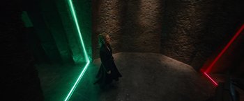 Movie still from “Fast X” (2023), directed by Justin Lin – A woman standing in a dark room with a green light; Wide shot, High angle