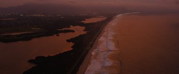 Movie still from “Fast X” (2023), directed by Justin Lin – An aerial view of the ocean and a beach at night; Extreme Wide shot, High angle
