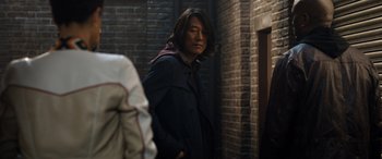 Movie still from “Fast X” (2023), directed by Justin Lin – A man standing in front of a brick wall; Medium shot, Over the shoulder angle