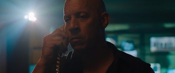 Movie still from “Fast X” (2023), directed by Justin Lin – A bald man is talking on a phone; Close Up shot, Low angle
