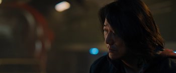 Movie still from “Fast X” (2023), directed by Justin Lin – A man with long hair is looking to his left; Close Up shot, Over the shoulder angle