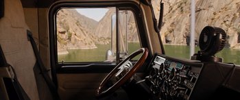 Movie still from “Fast X” (2023), directed by Justin Lin – A steering wheel of a truck with a lake in the background; Extreme Wide shot, High angle