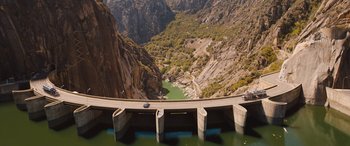 Movie still from “Fast X” (2023), directed by Justin Lin – A view of a bridge that is going over a river; Extreme Wide shot, High angle
