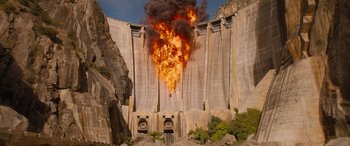 Movie still from “Fast X” (2023), directed by Justin Lin – A fire is burning in the middle of a dam wall; Extreme Wide shot, High angle