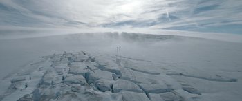 Movie still from “Fast X” (2023), directed by Justin Lin – Two people are standing on a snowy hill; Extreme Wide shot, High angle