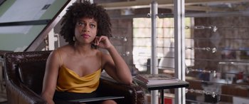 Movie still from “Father of the Bride” (2022), directed by Gary Alazraki – A woman sitting in a chair with her hand under her chin; Medium shot, Over the shoulder angle