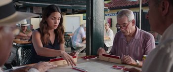 Movie still from “Father of the Bride” (2022), directed by Gary Alazraki – Two people are playing a card game at a table; Medium shot, Over the shoulder angle
