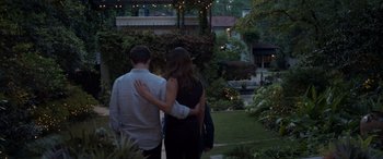 Movie still from “Father of the Bride” (2022), directed by Gary Alazraki – A man and a woman are walking in a garden together; Wide shot, High angle