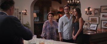 Movie still from “Father of the Bride” (2022), directed by Gary Alazraki – A group of people standing in front of a table; Medium shot, Over the shoulder angle