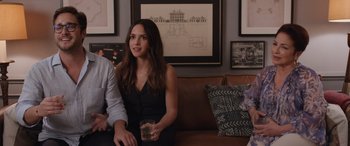 Movie still from “Father of the Bride” (2022), directed by Gary Alazraki – A woman sitting next to a man holding a drink; Medium shot, Over the shoulder angle