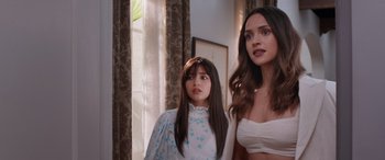 Movie still from “Father of the Bride” (2022), directed by Gary Alazraki – Two women standing next to each other in front of a window; Medium shot, Over the shoulder angle