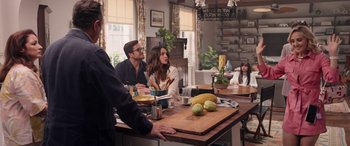 Movie still from “Father of the Bride” (2022), directed by Gary Alazraki – A group of people sitting at a table with food; Wide shot, Over the shoulder angle