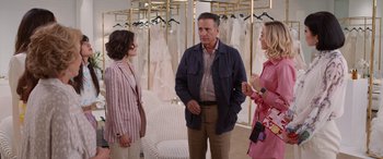 Movie still from “Father of the Bride” (2022), directed by Gary Alazraki – A man and two women standing in front of a mirror; Medium shot, Over the shoulder angle