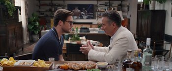 Movie still from “Father of the Bride” (2022), directed by Gary Alazraki – Two men are sitting at a table talking; Medium shot, Over the shoulder angle