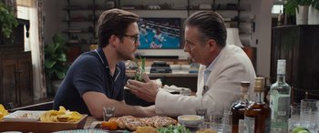 Movie still from “Father of the Bride” (2022), directed by Gary Alazraki – Two men sitting at a table with a pizza; Close Up shot, Over the shoulder angle