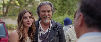 Movie still from “Father of the Bride” (2022), directed by Gary Alazraki – An older man with long grey hair standing next to a young woman; Close Up shot, Over the shoulder angle