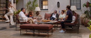 Movie still from “Father of the Bride” (2022), directed by Gary Alazraki – A group of people sitting around a table with food; Wide shot, High angle