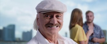 Movie still from “Father of the Bride” (2022), directed by Gary Alazraki – An older man with a white hat and mustache; Close Up shot, Low angle