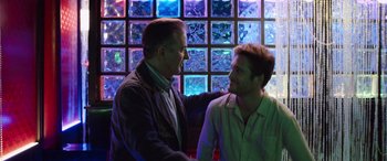 Movie still from “Father of the Bride” (2022), directed by Gary Alazraki – A man and a man shake hands in front of a glass wall; Medium shot, Over the shoulder angle