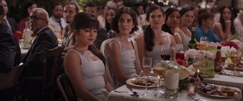 Movie still from “Father of the Bride” (2022), directed by Gary Alazraki – A group of women sitting at a table with wine glasses; Medium shot, Over the shoulder angle