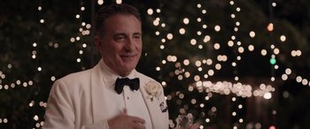 Movie still from “Father of the Bride” (2022), directed by Gary Alazraki – A man in a white tuxedo holding a glass of champagne; Close Up shot, Over the shoulder angle