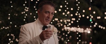 Movie still from “Father of the Bride” (2022), directed by Gary Alazraki – A man in a white tuxedo holding a cell phone in his hand; Close Up shot, Over the shoulder angle