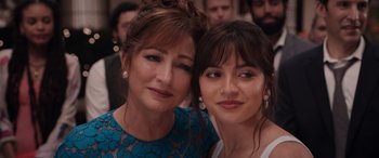 Movie still from “Father of the Bride” (2022), directed by Gary Alazraki – Two women posing for a picture in front of a crowd; Close Up shot, Over the shoulder angle