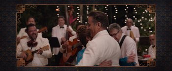 Movie still from “Father of the Bride” (2022), directed by Gary Alazraki – A man and a woman hugging in front of a group of people; Medium shot, Over the shoulder angle