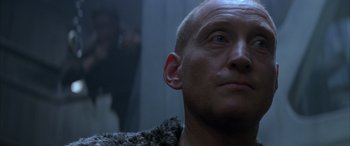 Movie still from “Alien³” (1992), directed by David Fincher – A man with a shaved head looking into a mirror; Close Up shot, Low angle
