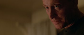 Movie still from “Alien³” (1992), directed by David Fincher – A person's face with a blurry background; Close Up shot, Over the shoulder angle