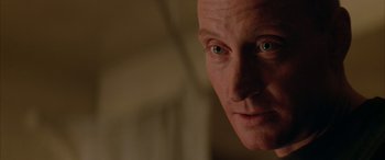 Movie still from “Alien³” (1992), directed by David Fincher – A man's face in a dark room; Close Up shot, Over the shoulder angle