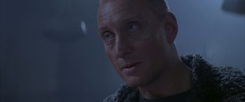 Movie still from “Alien³” (1992), directed by David Fincher – A man's face in a dark room; Close Up shot, Over the shoulder angle