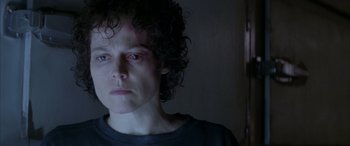 Movie still from “Alien³” (1992), directed by David Fincher – A woman with curly hair is looking at the camera; Close Up shot, Over the shoulder angle