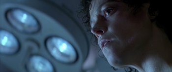 Movie still from “Alien³” (1992), directed by David Fincher – A woman's face in front of a mirror; Close Up shot, Low angle