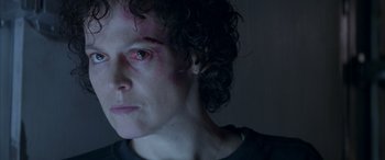 Movie still from “Alien³” (1992), directed by David Fincher – A person's face in a dark room; Close Up shot, Over the shoulder angle