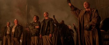 Movie still from “Alien³” (1992), directed by David Fincher – A group of men standing next to each other on top of a building; Medium shot, Low angle