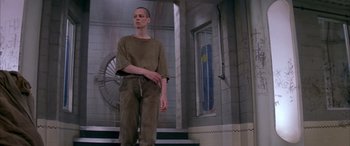 Movie still from “Alien³” (1992), directed by David Fincher – A man standing in front of a building; Wide shot, Low angle