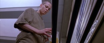 Movie still from “Alien³” (1992), directed by David Fincher – A man in tan shirt holding a glass of orange juice; Close Up shot, Low angle