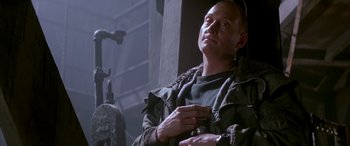 Movie still from “Alien³” (1992), directed by David Fincher – A man is looking up while holding a cell phone in his hand; Medium shot, Low angle